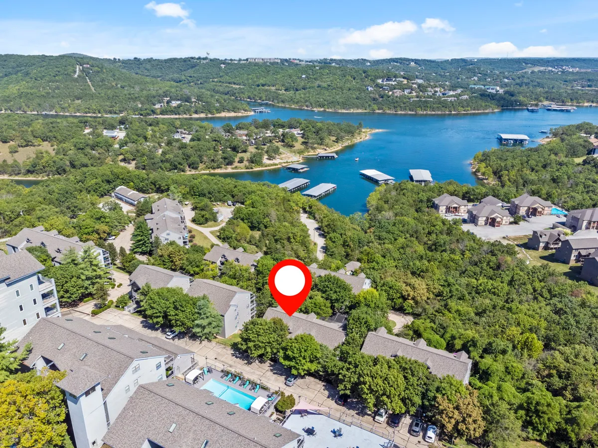 A panoramic view of Table Rock Lake framed by lush greenery and dotted with marinas in the distance. The image highlights the sparkling water, inviting visitors to enjoy activities like boating, fishing, and lakeside relaxation.