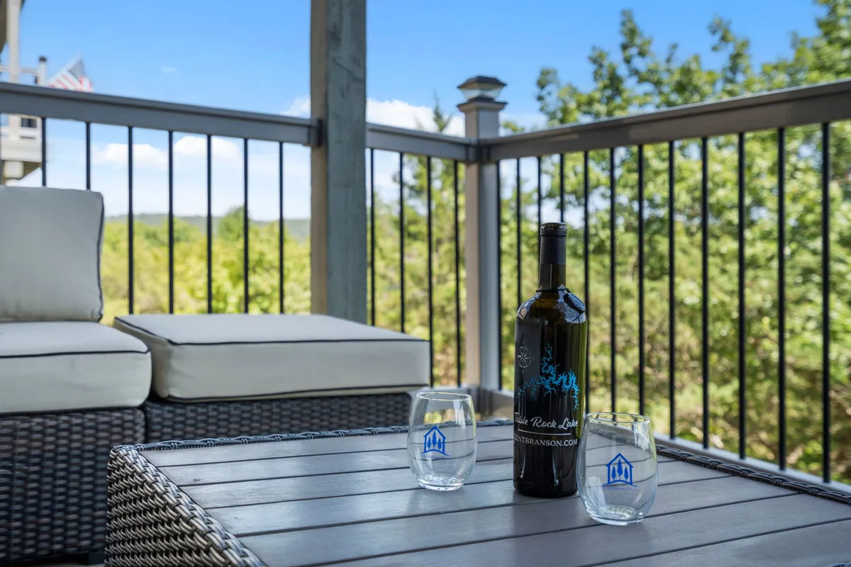 A cozy outdoor seating area with a couch, wine glasses, and a scenic backdrop of nature. The mood is relaxing—ideal for unwinding after a day of exploring, with a sense of privacy and comfort.